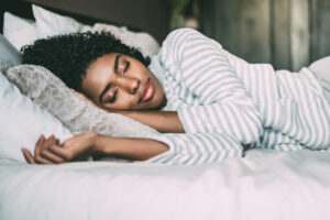 woman with curly hair sleeping in bed