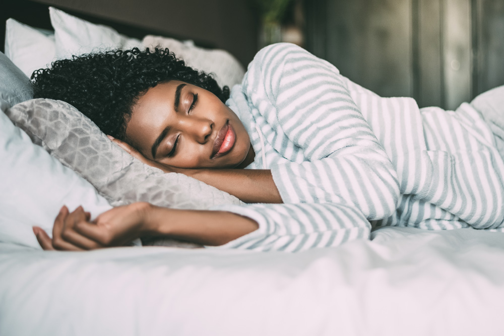 woman with curly hair sleeping in bed